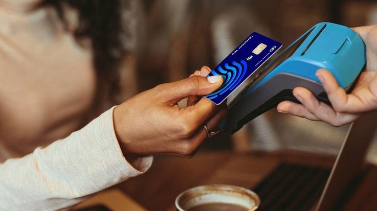 A woman pays for her coffee contactlessly with the Convego You credit card